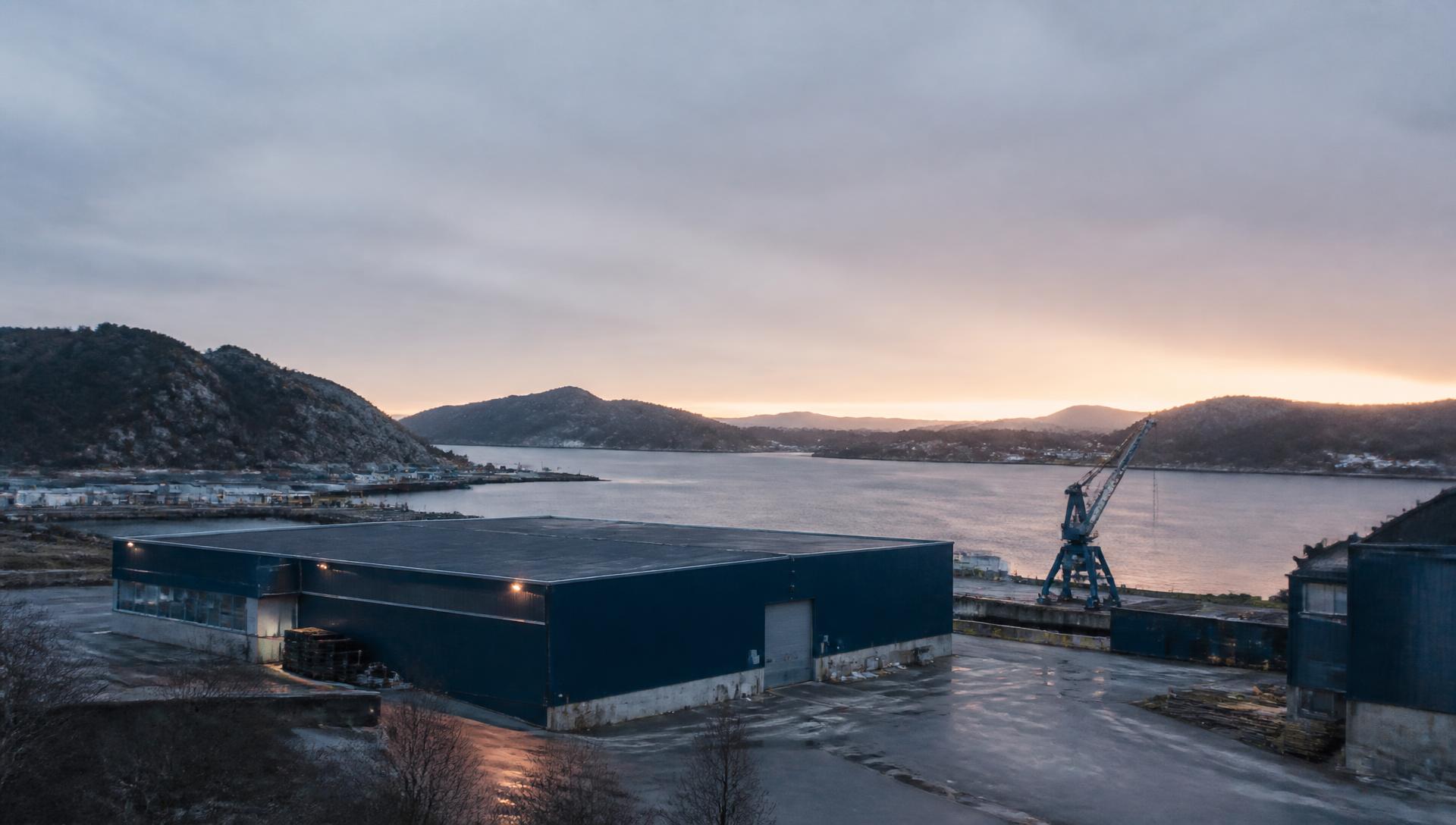 Næringsområde ved sjøen i Agder i tidlig morgenlys